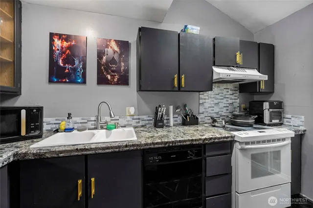 a kitchen with stainless steel appliances granite countertop a sink stove and cabinets