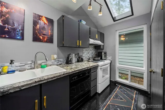 a kitchen with granite countertop a sink stainless steel appliances and cabinets