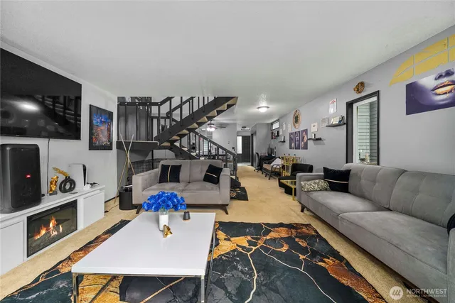 a living room with furniture a flat screen tv and a book shelf