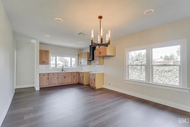 a kitchen with stainless steel appliances wooden floors and white cabinets