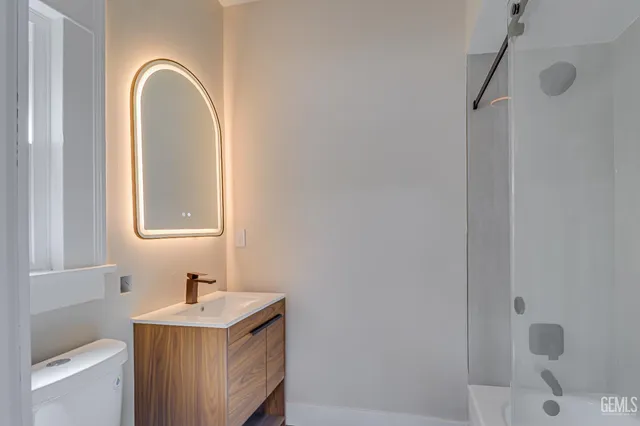a bathroom with a sink a toilet and shower