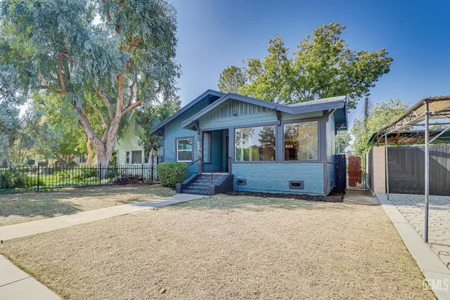 a front view of a house with a yard and potted plants