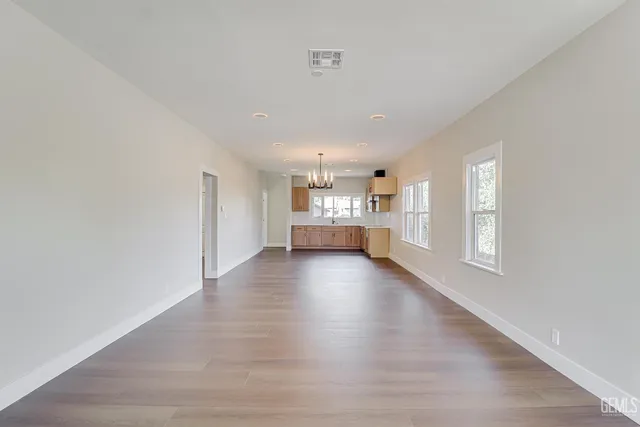 a view of kitchen and hall with wooden floor