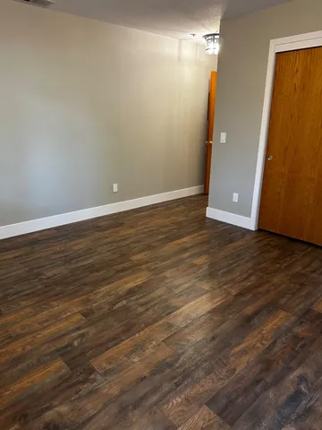 a view of an empty room with wooden floor