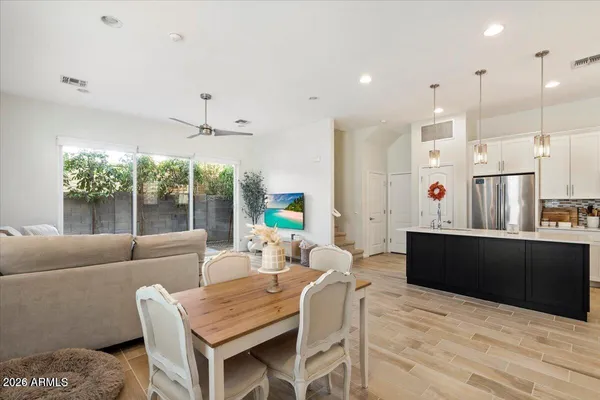 a living room with furniture a large window and wooden floors