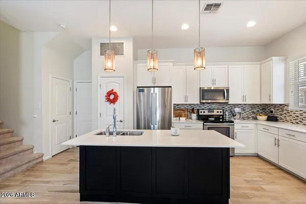 a kitchen with stainless steel appliances a sink stove and refrigerator