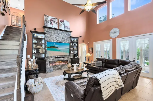 a living room with furniture a fireplace and a floor to ceiling window