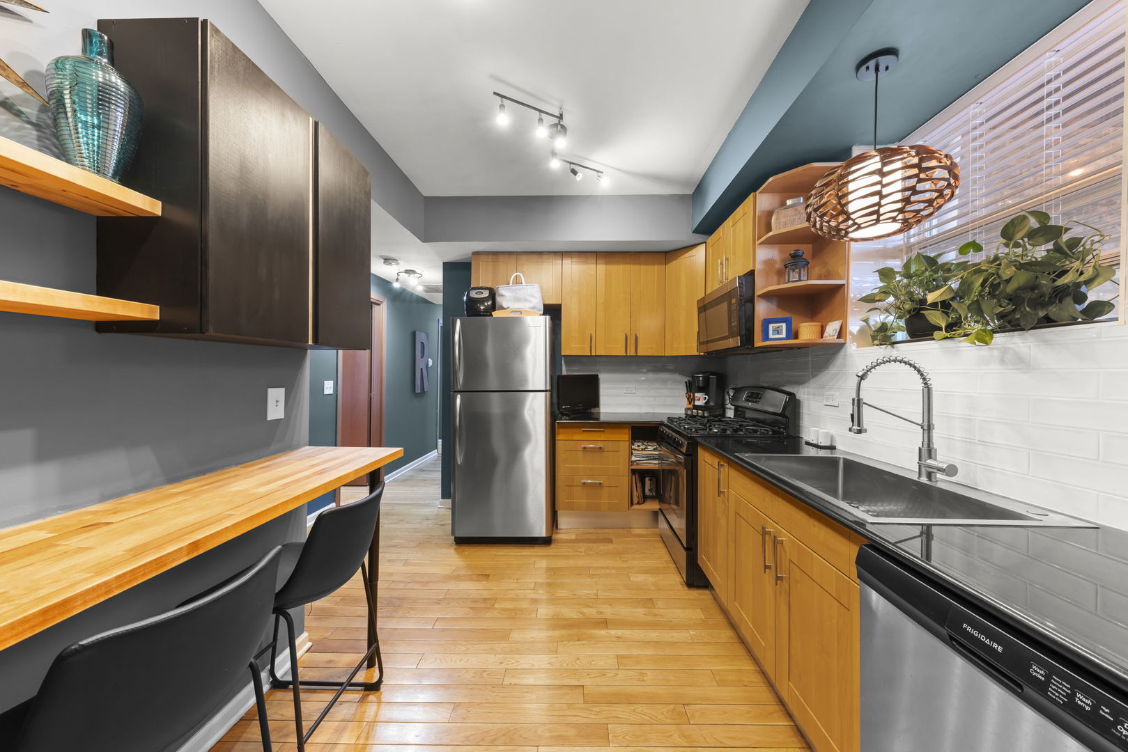 5054 North Troy Street, Unit 3 Chicago, IL 60625 - Photo 7 of 31 a kitchen with stainless steel appliances granite countertop a refrigerator a sink dishwasher a stove and white countertops with wooden floor