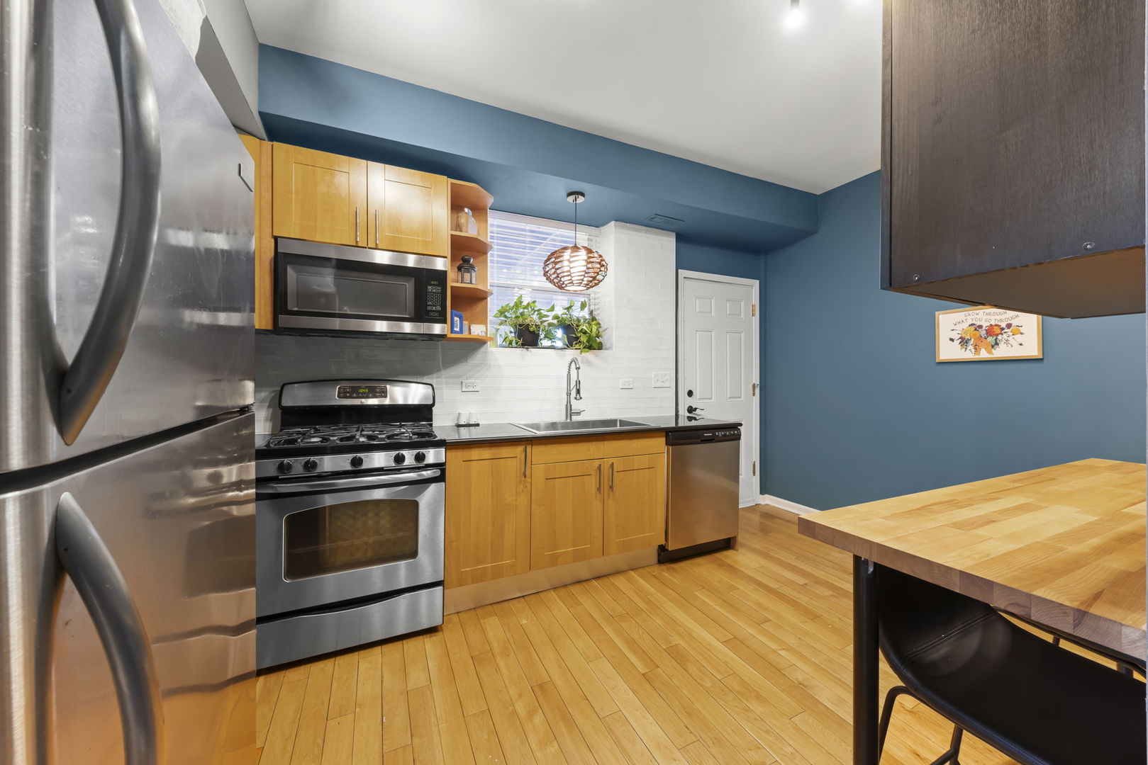 5054 North Troy Street, Unit 3 Chicago, IL 60625 - Photo 9 of 31 a kitchen with stainless steel appliances a stove a microwave and a hard wood floor