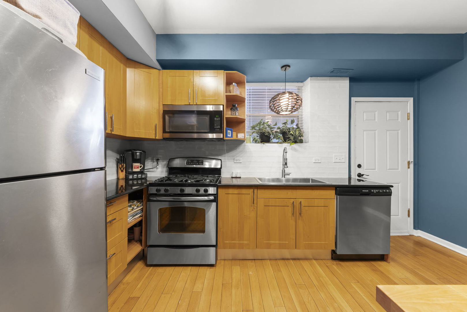 5054 North Troy Street, Unit 3 Chicago, IL 60625 - Photo 10 of 31 a kitchen with stainless steel appliances granite countertop a stove a sink and a refrigerator