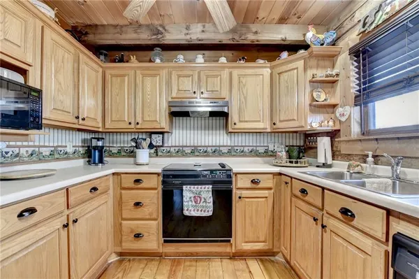 a kitchen with stainless steel appliances granite countertop a sink a stove and cabinets