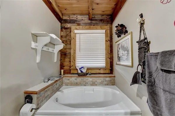 a bathroom with a tub sink and mirror