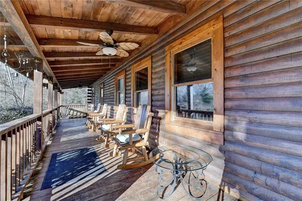 a view of a patio with table and chairs with wooden floor and fence