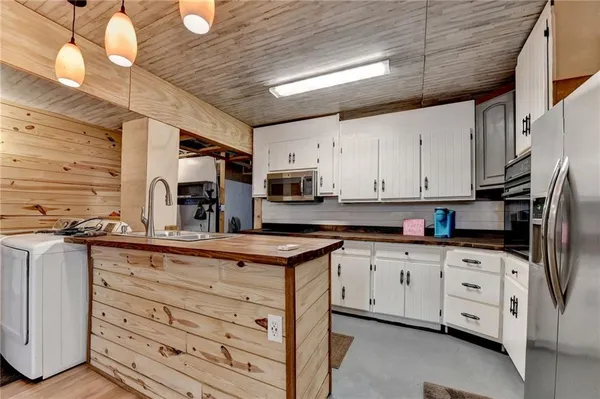 a kitchen with granite countertop white cabinets and stainless steel appliances