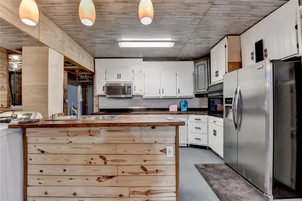 a kitchen with stainless steel appliances kitchen island granite countertop a stove refrigerator and cabinets