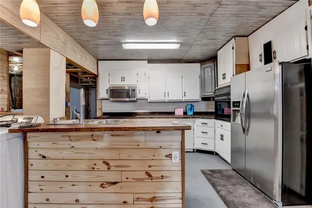 a kitchen with stainless steel appliances kitchen island granite countertop a stove refrigerator and cabinets
