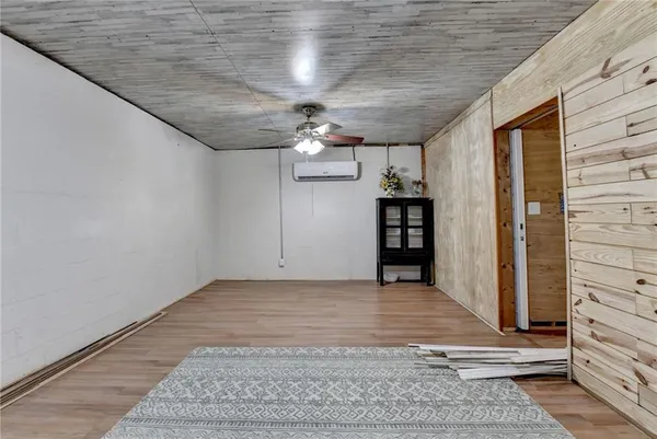 a view of a hallway with wooden floor and a kitchen space