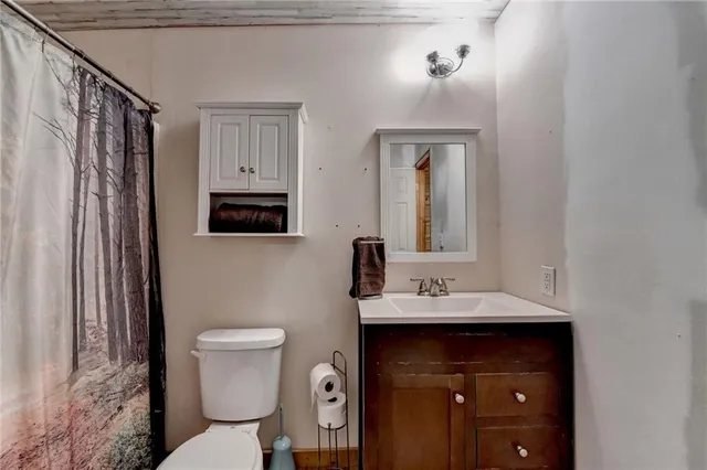 a bathroom with a toilet sink and mirror