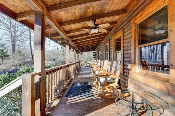 a view of a patio with table and chairs with wooden floor and fence