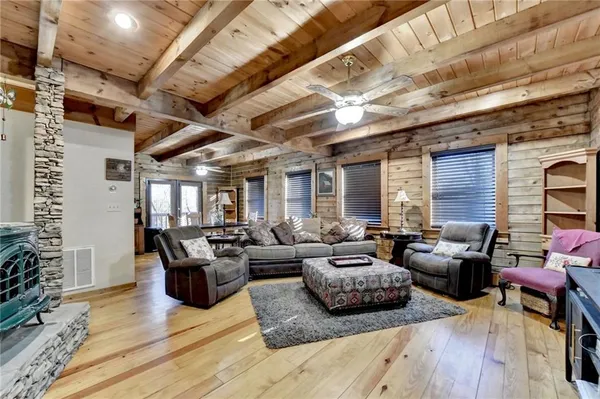a living room with furniture kitchen view and a large window