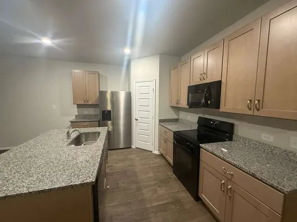 a kitchen with a sink microwave and refrigerator