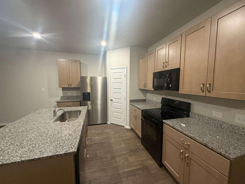 2711 Totley Road Manor, TX 78653 - Photo 15 of 40 a kitchen with a sink stove and microwave