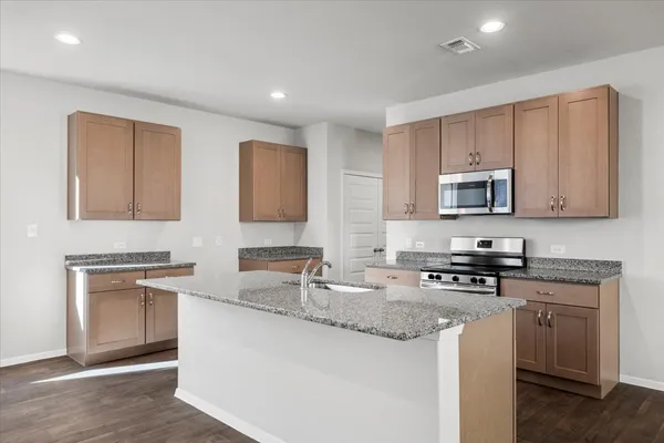 a kitchen with stainless steel appliances granite countertop a sink stove and microwave