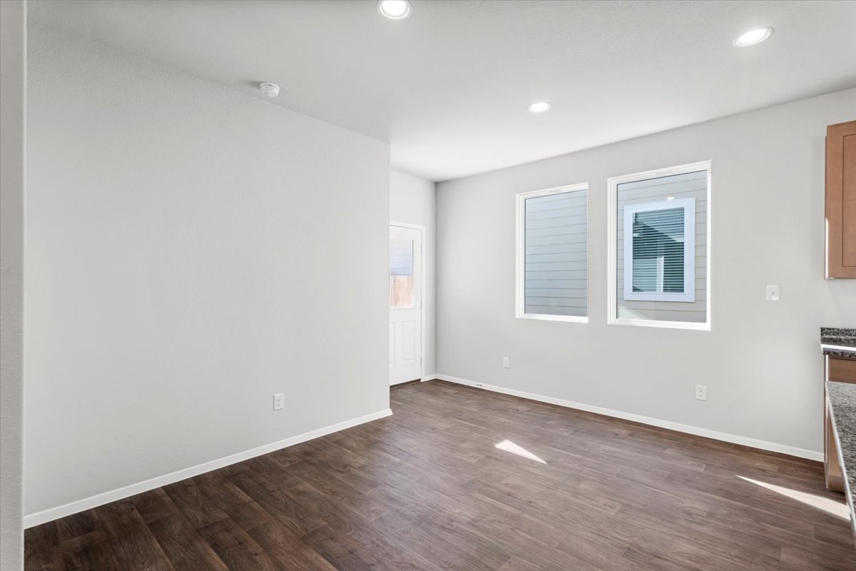 2711 Totley Road Manor, TX 78653 - Photo 17 of 40 an empty room with wooden floor and windows