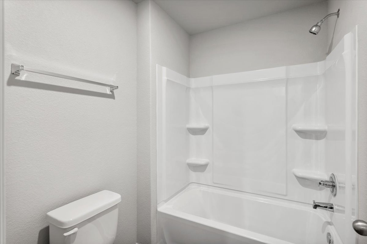 2711 Totley Road Manor, TX 78653 - Photo 30 of 40 a white bath tub sitting next to a white toilet and sink