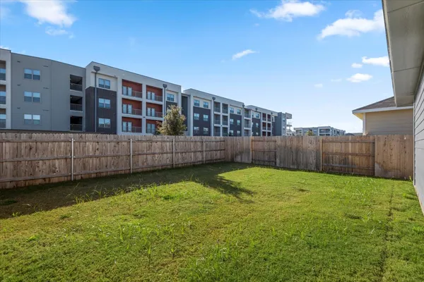 a view of a backyard with a fence and wooden fence