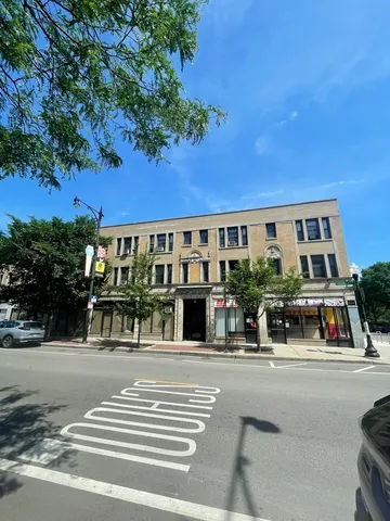 a view of a building and car parked on the road