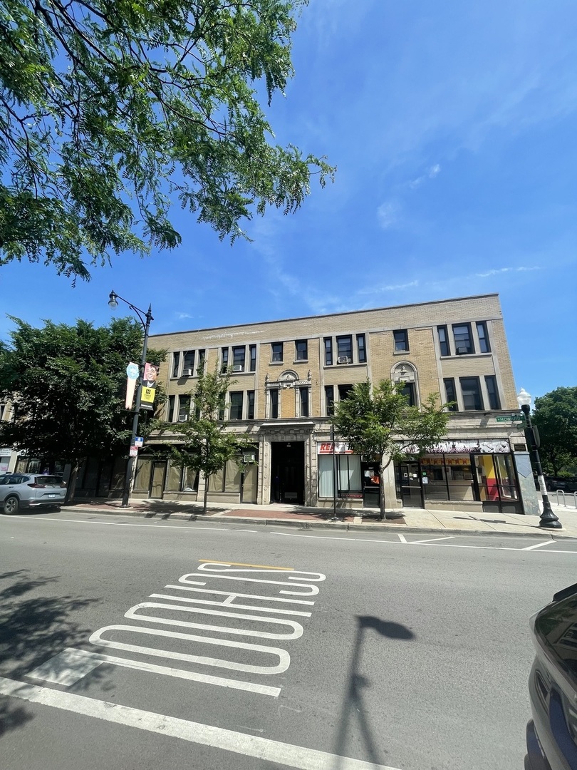a view of a building and car parked on the road