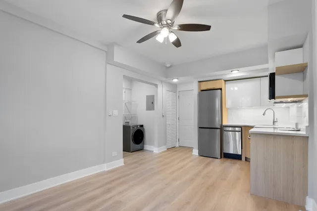 a view of kitchen with stainless steel appliances granite countertop cabinets and wooden floor