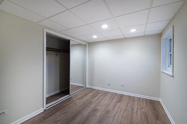 a view of a room with wooden floor lounge chair and windows