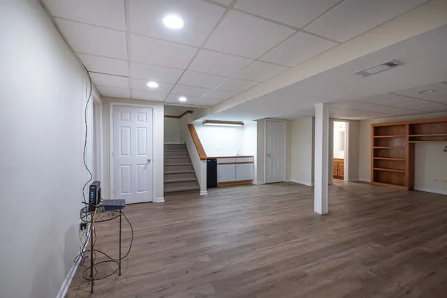 a view of a livingroom with wooden floor and stairs