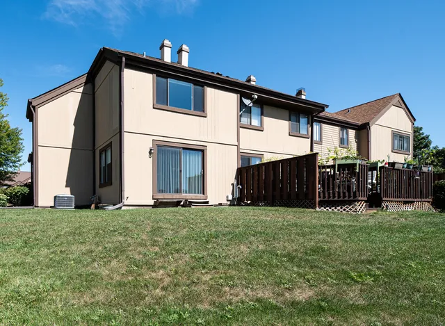 a view of a house with a yard and wooden fence