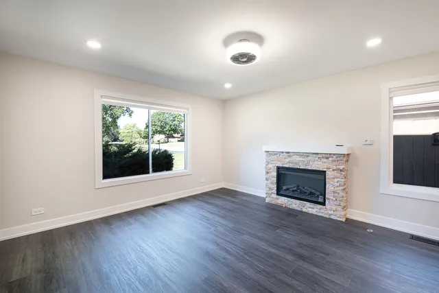 a kitchen with stainless steel appliances granite countertop a sink a stove a refrigerator and island with wooden floor