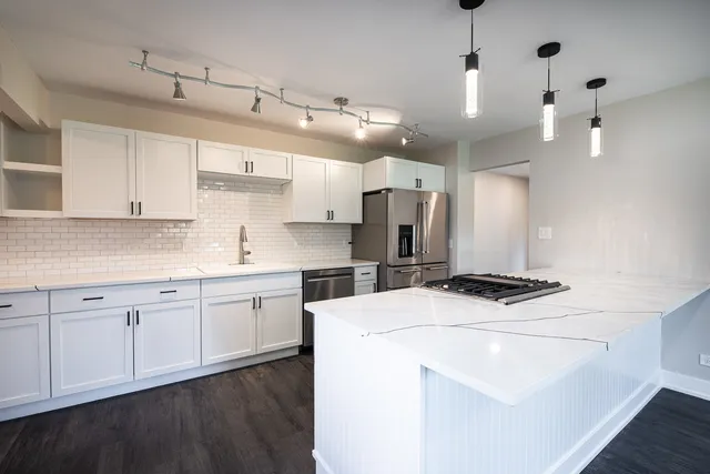 a large kitchen with cabinets and wooden floor