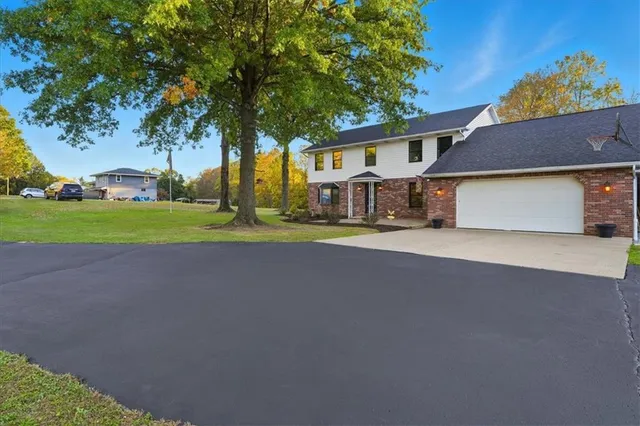 a view of a house with a big yard and large trees
