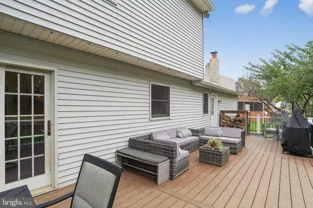 a roof deck with a table and chairs and potted plants