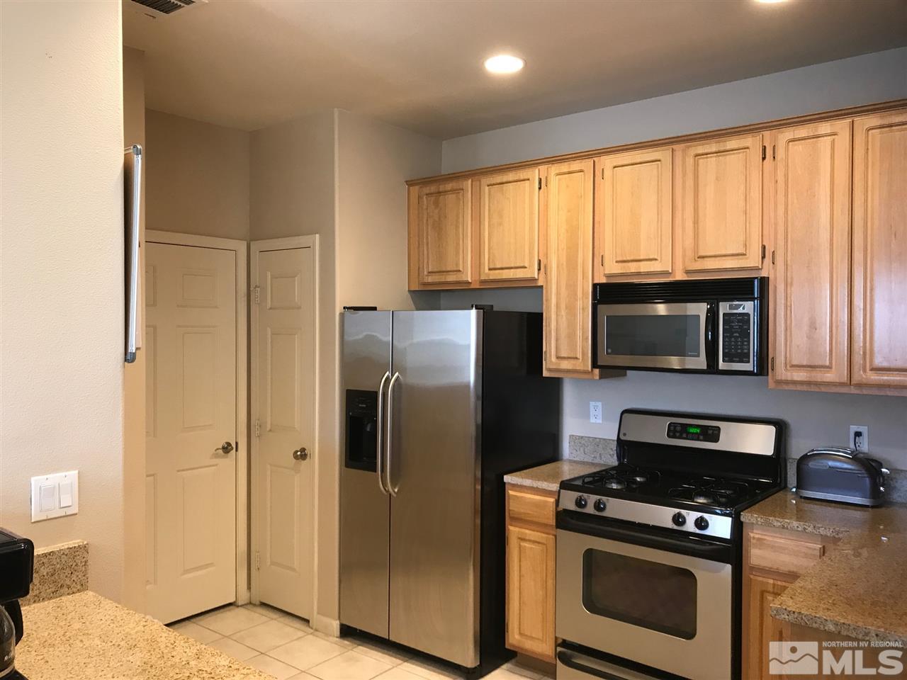 900 South, Unit 2424 Reno, NV 89521 - Photo 5 of 9 a kitchen with stainless steel appliances granite countertop a stove a refrigerator and a microwave