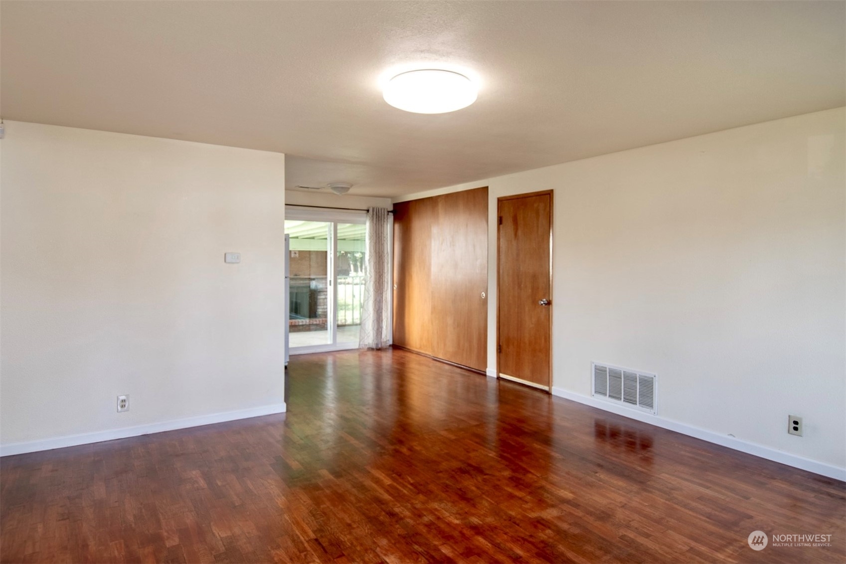 17039 123rd Avenue Southeast Renton, WA 98058 - Photo 2 of 11 a view of an empty room with wooden floor and a window