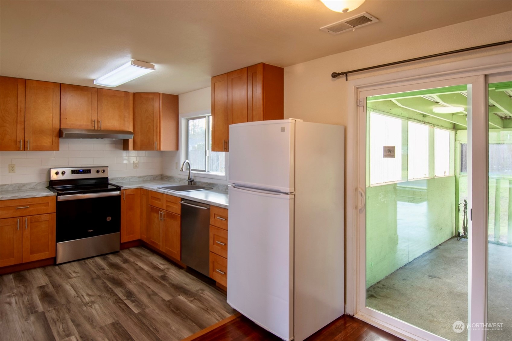 17039 123rd Avenue Southeast Renton, WA 98058 - Photo 4 of 11 a kitchen with a refrigerator and a stove top oven