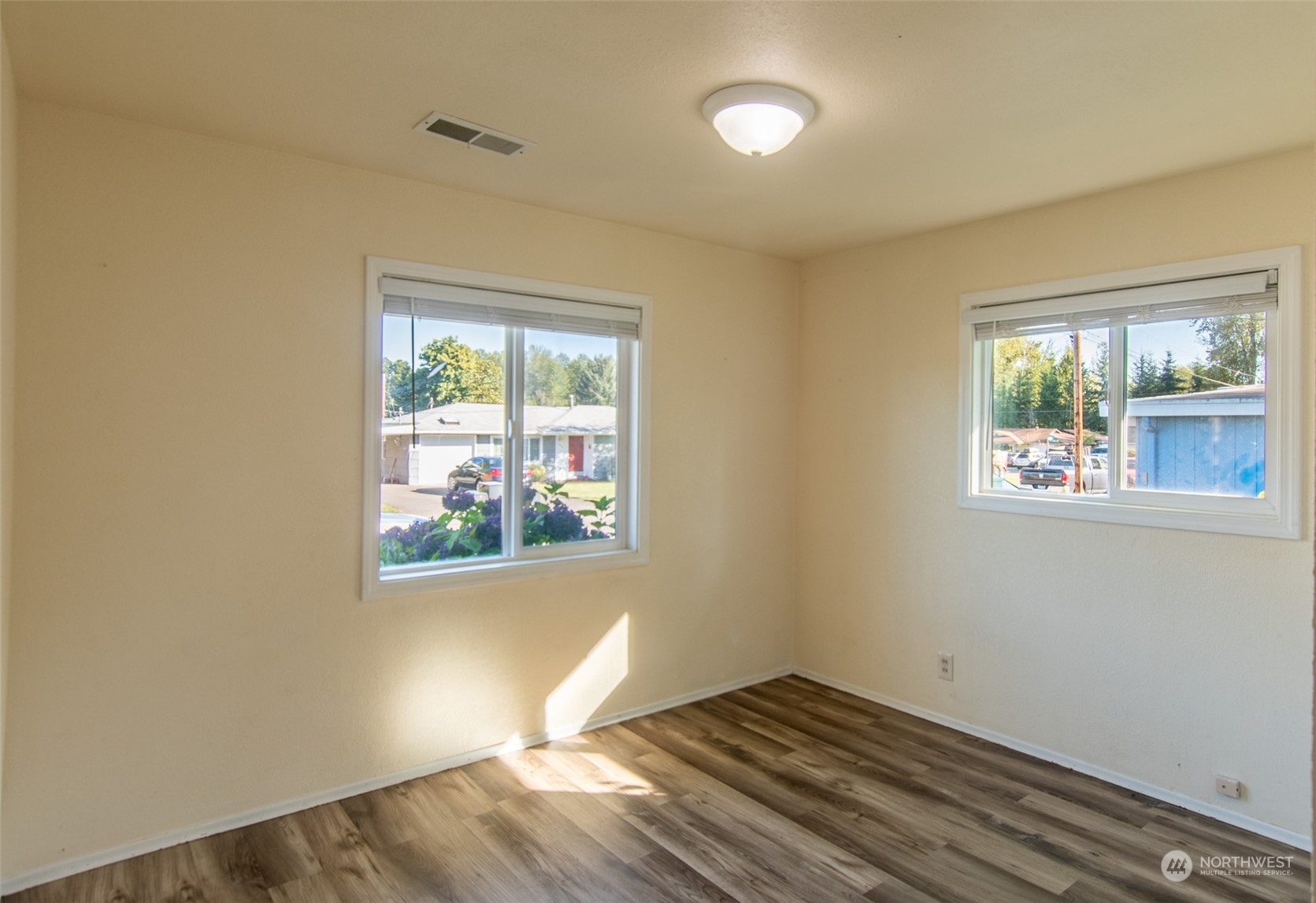 17039 123rd Avenue Southeast Renton, WA 98058 - Photo 7 of 11 an empty room with wooden floor and windows