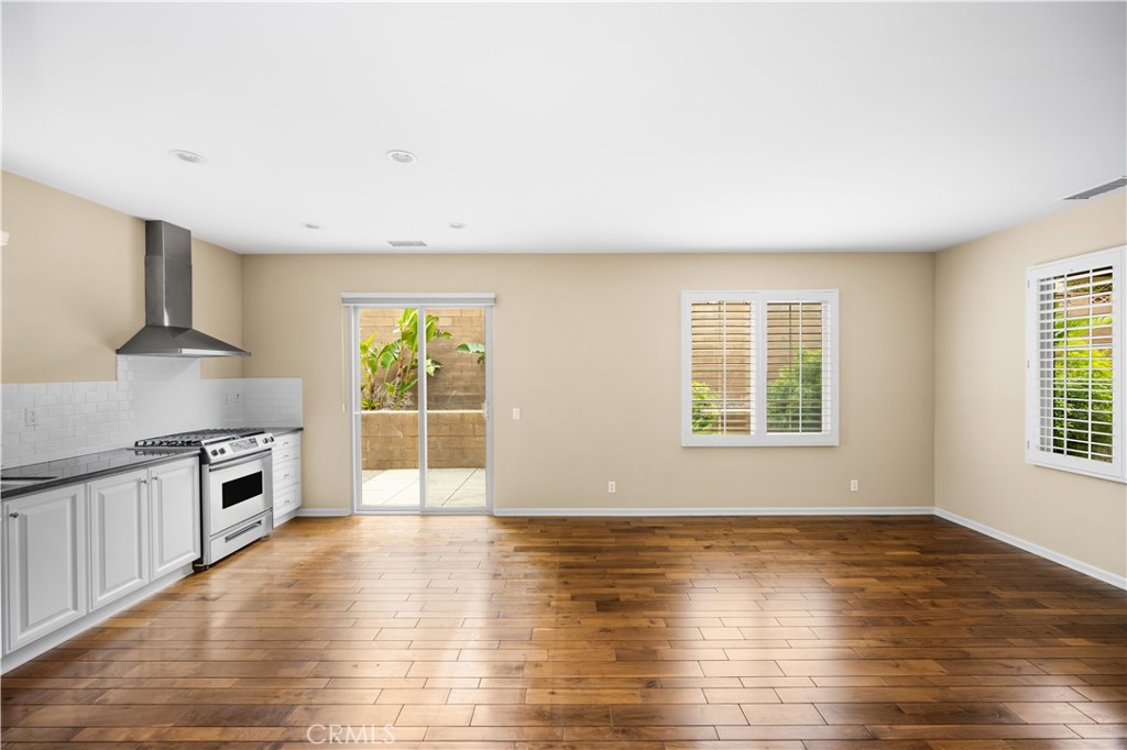 56 Pathway Irvine, CA 92618 - Photo 6 of 52 an empty room with wooden floor and windows