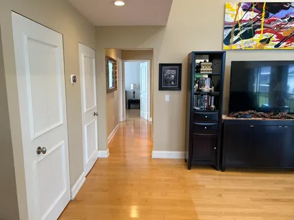 a view of a hallway with wooden floor and furniture