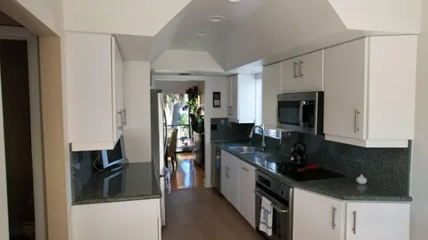 a kitchen with stainless steel appliances granite countertop a refrigerator and a stove top oven