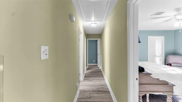 a view of a hallway with wooden floor and staircase