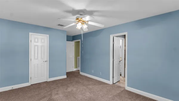 an empty room with windows and fan