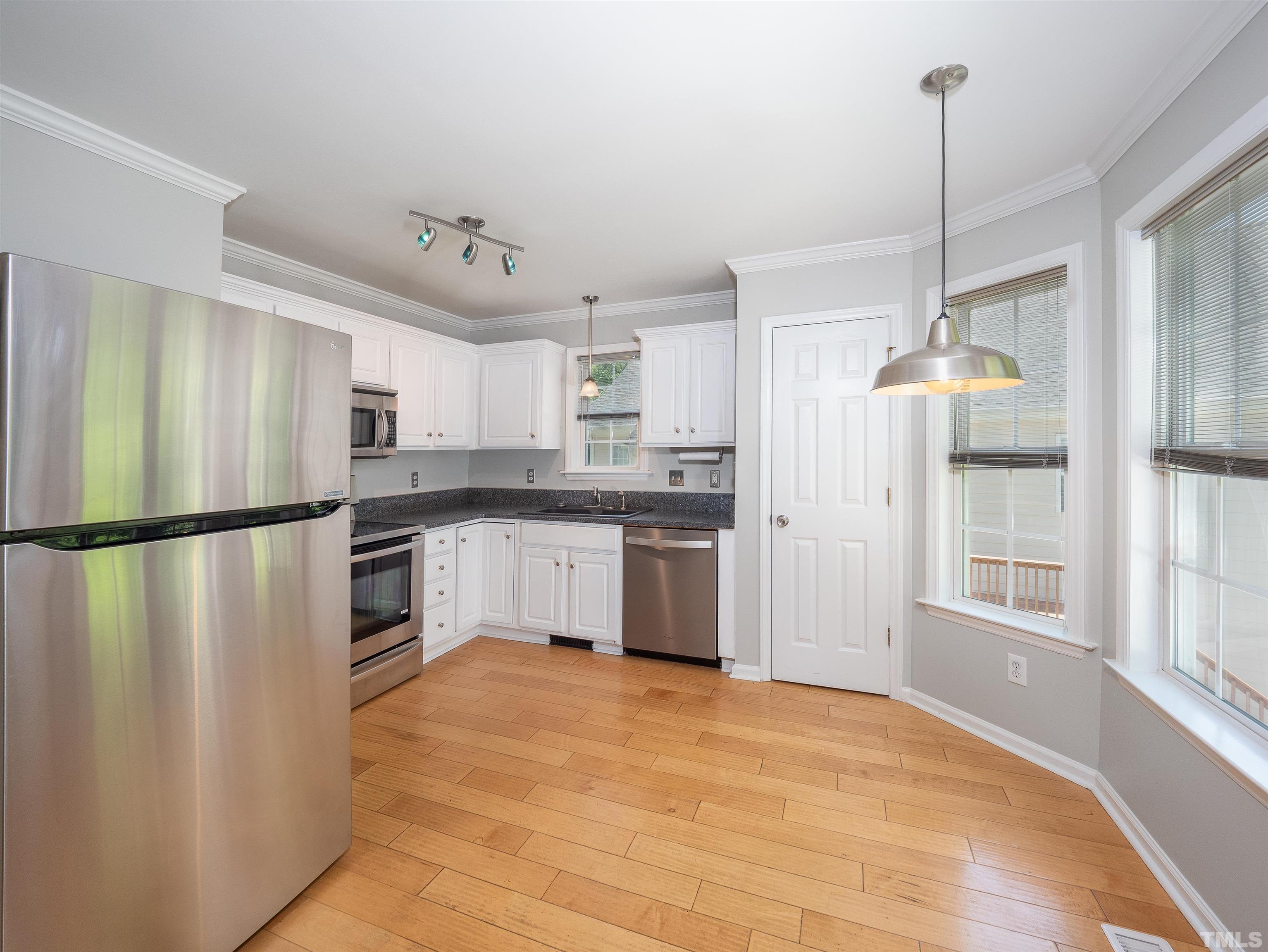 818 Shackleton Road Apex, NC 27502 - Photo 10 of 20 a kitchen with white cabinets and stainless steel appliances